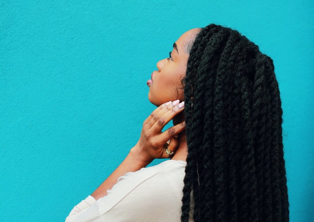 interpretive research institute A black scholar with long braids is leaning against a blue wall.