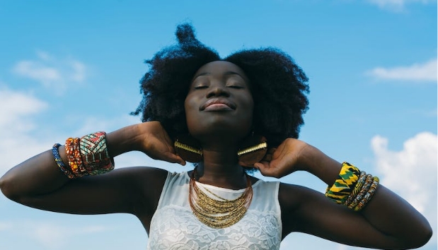 interpretive research institute A woman with afro hair posing gracefully in front of a blue sky.