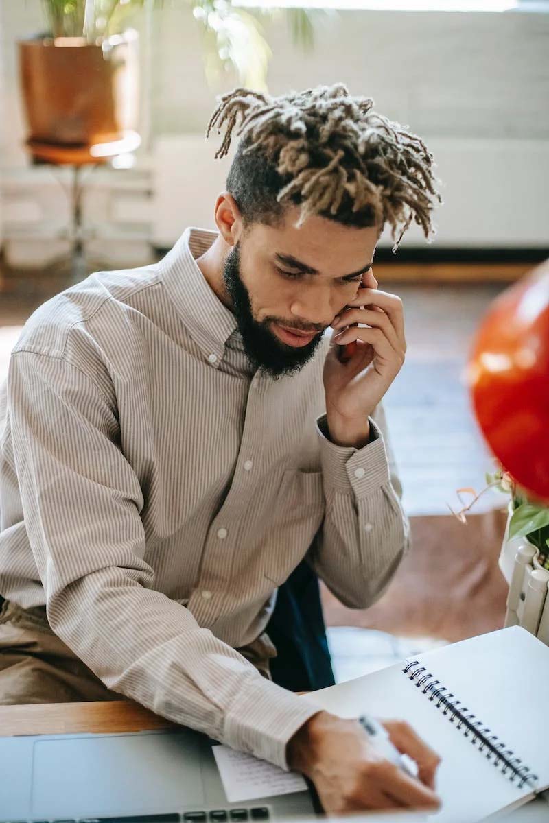 interpretive research institute A Black scholar with dreadlocks conversing on the phone at a desk.